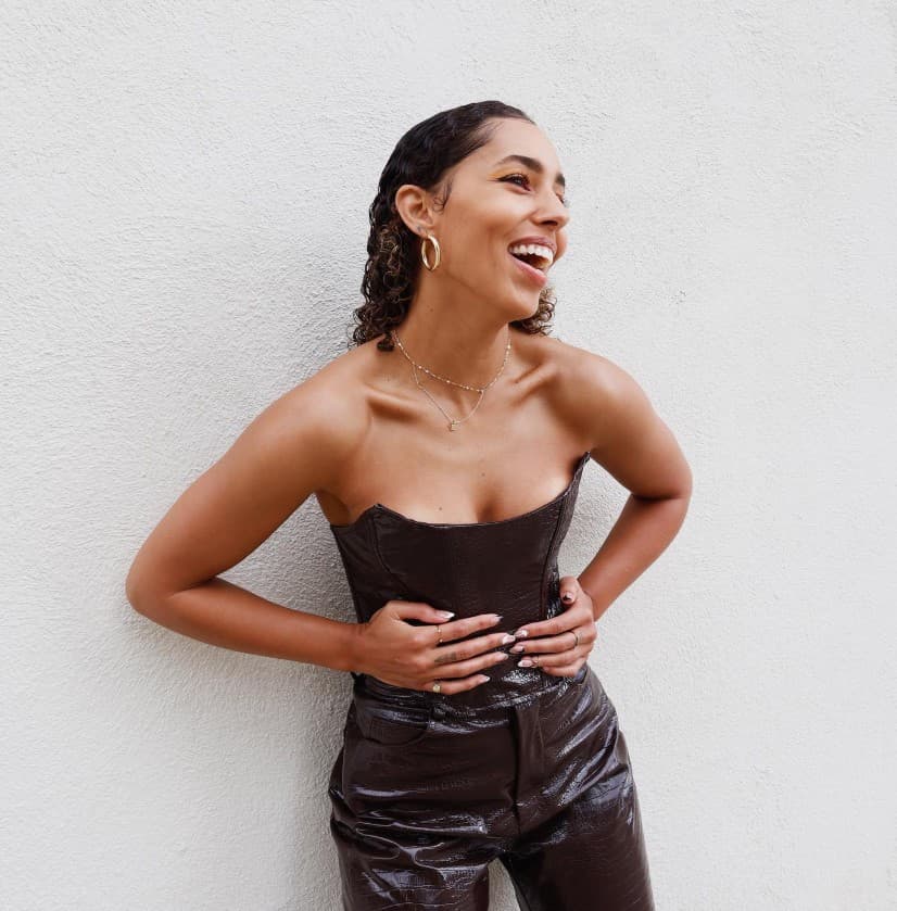 Linette, Mosona's founder, laughing in the sun against a white stone wall